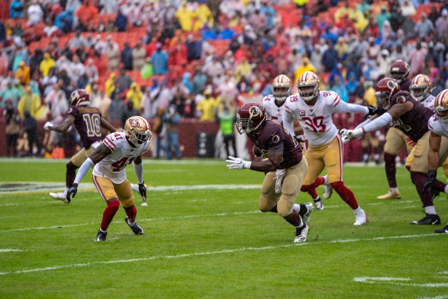 DeForest Buckner, number 99 in the 49ers' white road uniform, chases a Washington ball carrier in the rain at Washington on October 20, 2019, his last season with San Francisco.