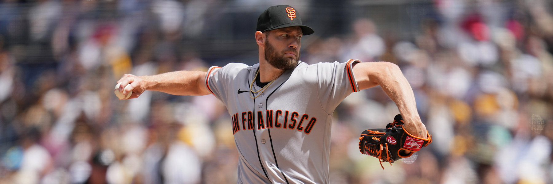 Adrian Houser at full extension on the mound in San Francisco's gray road uniform, SAN FRANCISCO in black and orange across the chest, the ball in his bare right hand behind him and his glove out in front.