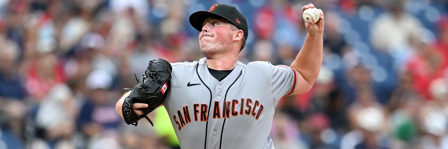 Matt Wilkinson in mid-delivery in San Francisco's grey road uniform, SAN FRANCISCO in black and orange across the chest, black cap with an orange SF, the ball in his raised left hand and his glove out in front of him. A league media photograph, not from Saturday.