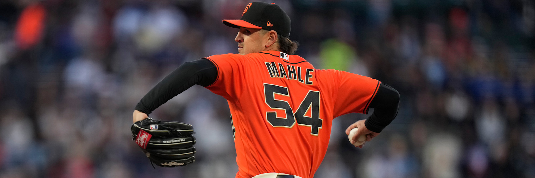 Tyler Mahle delivering a pitch for the San Francisco Giants in the orange alternate jersey, number 54