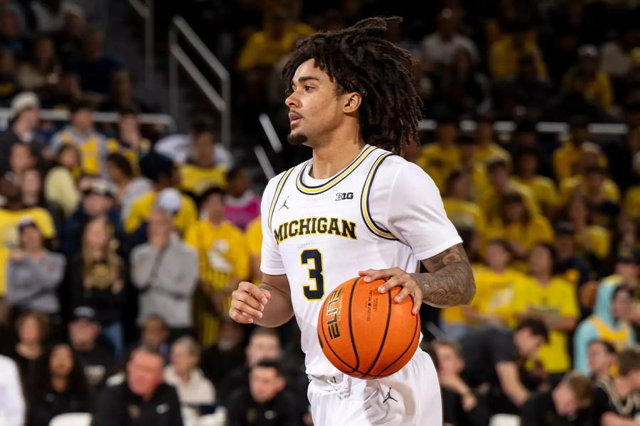 Elliot Cadeau, in Michigan's white home uniform, dribbles up the floor at Crisler Center during the Oakland game in November 2025.