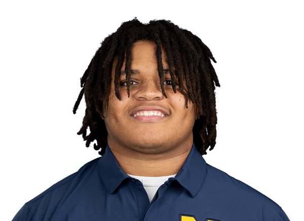 Ace Hamilton in an ESPN studio headshot, a heavy-framed young lineman in a navy Michigan team polo with the maize block M at the chest, smiling against a plain white background.