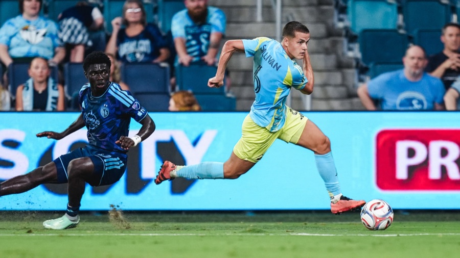 Cavan Sullivan in the Philadelphia Union's light blue and yellow away kit, running with the ball past a Sporting Kansas City defender at Children's Mercy Park on September 19, 2026. A club match photograph, not a United States match.